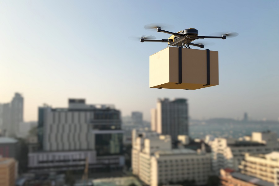 Drone delivering package into the city. Business air transportation. Unmanned aircraft robot concept. Fast air shipping. 